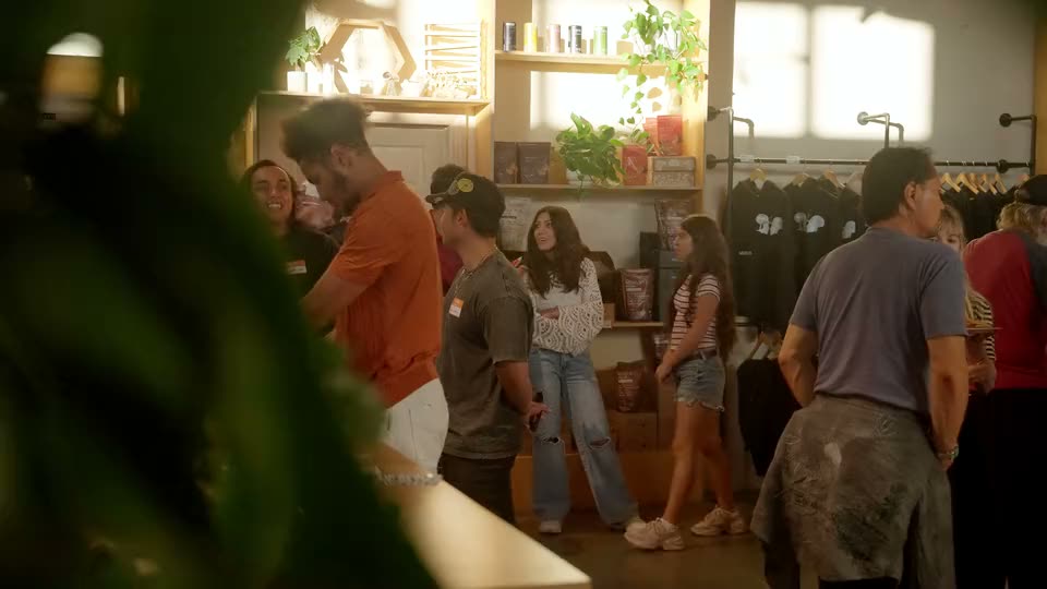 Guests talking in the shop, seen through the plants