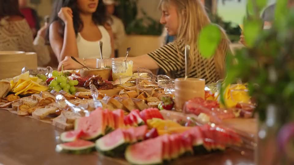Guests at a long table of fruit and snacks