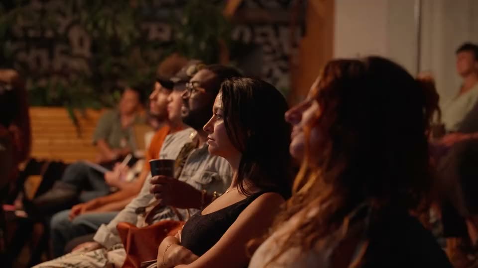 The audience in profile, watching the stage